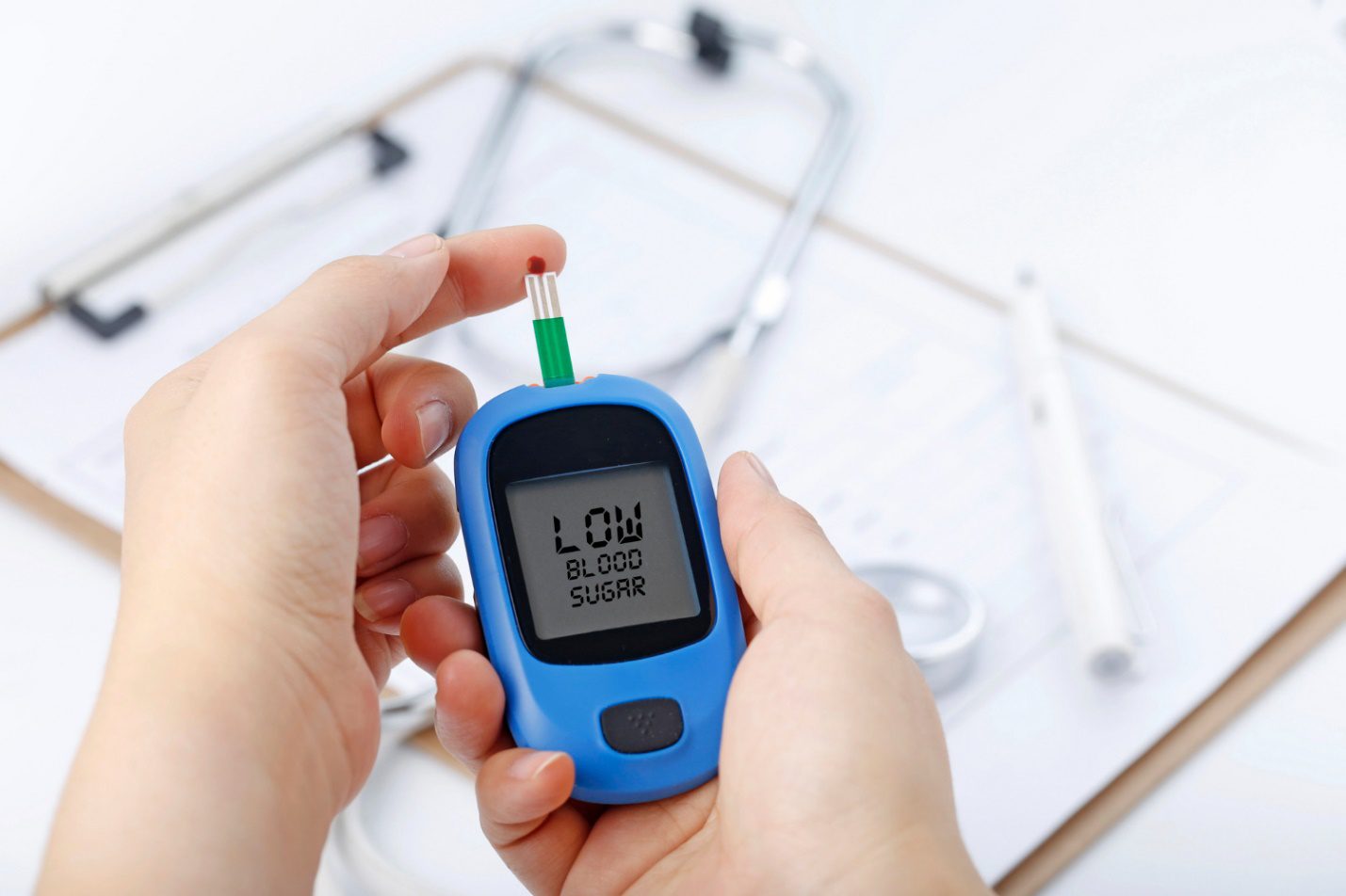 C:\Users\Dell\Downloads\hand-holding-blood-glucose-meter-measuring-blood-sugar-background-is-stethoscope-chart-file.jpg