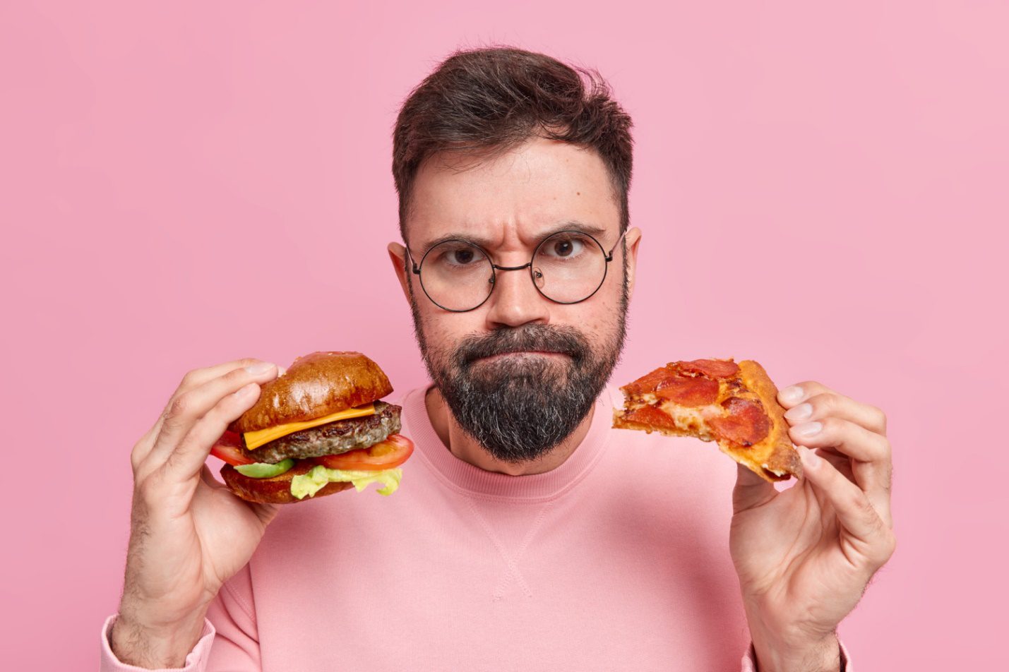 C:\Users\Dell\Downloads\man-holds-hamburger-pizza-presses-lips-wears-round-spectacles-jumper.jpg