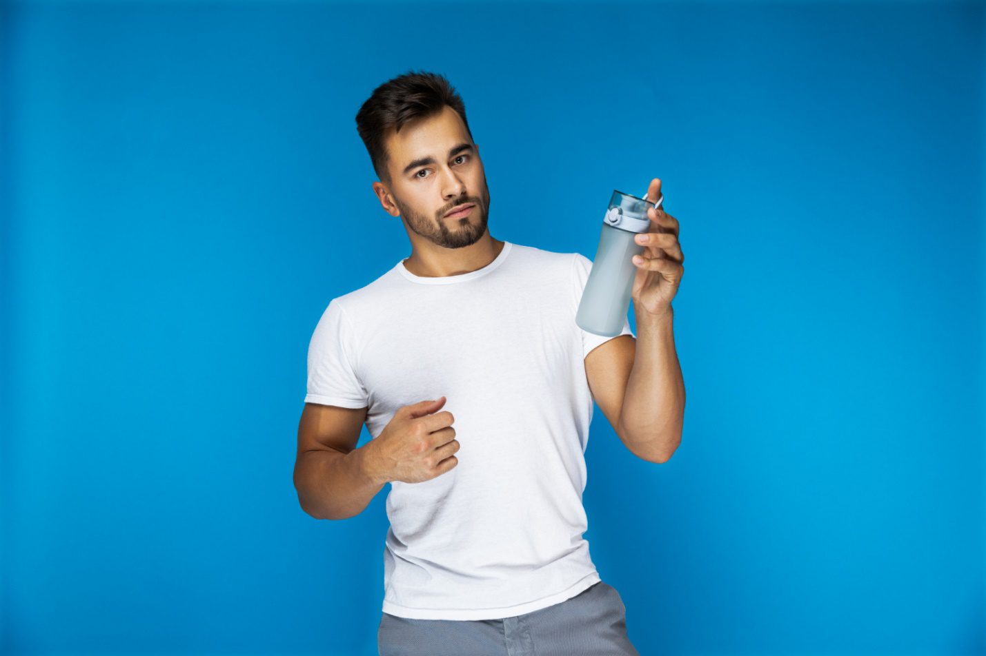 C:\Users\Dell\Downloads\handsome-european-man-white-t-shirt-blue-backgroung-is-holding-sport-bottle-hand.jpg